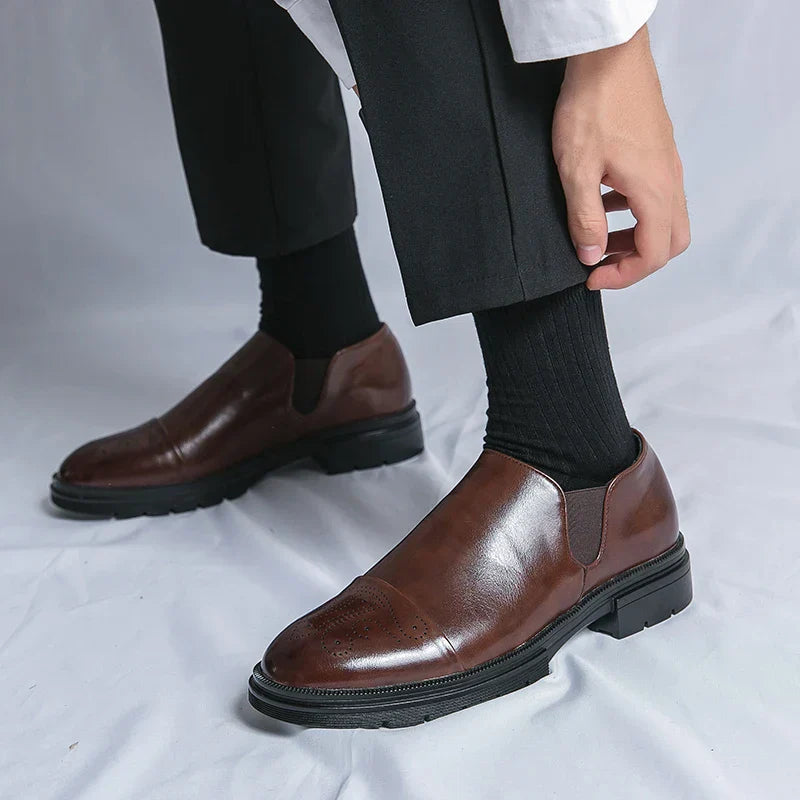 Scarpe eleganti uomo in pelle marrone, design slip-on, indossate con pantaloni neri e calze scure. Moda maschile, calzature classiche.