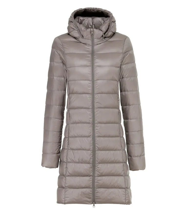 Giacca piumino lungo grigio con cappuccio, chiusura a zip, design trapuntato. Moda invernale donna, abbigliamento caldo ed elegante.