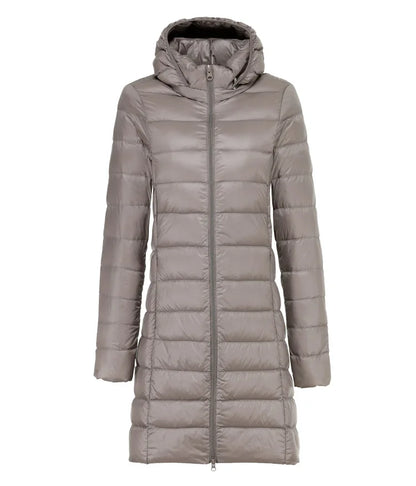 Giacca piumino lungo grigio con cappuccio, chiusura a zip, design trapuntato. Moda invernale donna, abbigliamento caldo ed elegante.