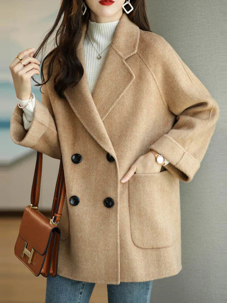 Donna con cappotto beige elegante, doppio petto, abbinato a jeans e borsa marrone. Moda autunnale, stile casual chic, accessori moderni.