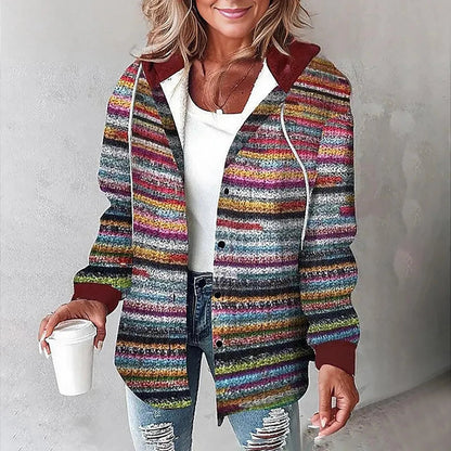 Donna con cardigan a righe multicolore, cappuccio rosso, maglia bianca e jeans strappati, tiene una tazza di caffè. Moda casual autunnale.