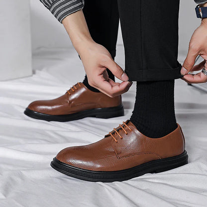 Scarpe eleganti in pelle marrone per uomo, abbinate a pantaloni neri e calzini scuri. Design classico, ideale per look formali e business casual.