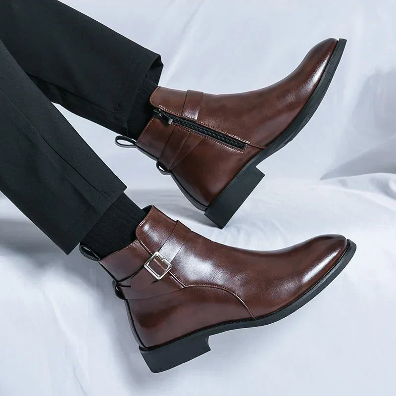 Stivali Chelsea uomo in pelle marrone con fibbia e cerniera, eleganti e moderni, indossati con pantaloni neri. Scarpe moda autunno inverno.
