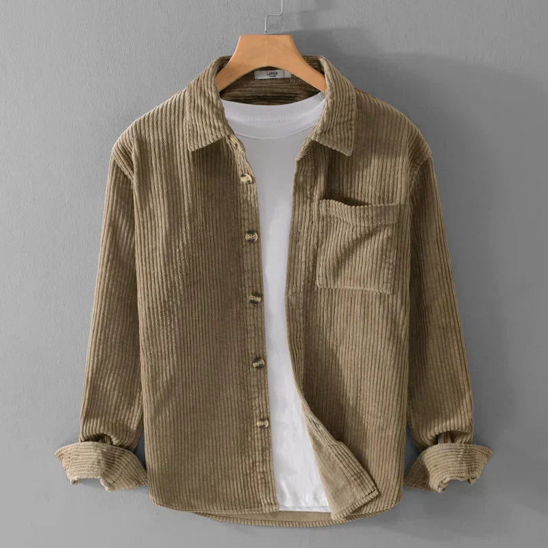 Camicia di velluto a coste marrone chiaro su gruccia, con tasca frontale e bottoni, sopra una maglietta bianca. Moda casual uomo, abbigliamento autunnale.