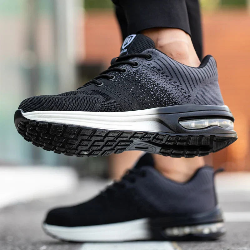 Scarpe da ginnastica nere con suola ammortizzata, design moderno e dettagli a rete, ideali per corsa e sport. Comfort e stile urbano.