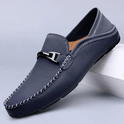Mocassino uomo in pelle blu scuro con cuciture bianche e dettaglio metallico, suola antiscivolo. Scarpe eleganti e casual per ogni occasione.