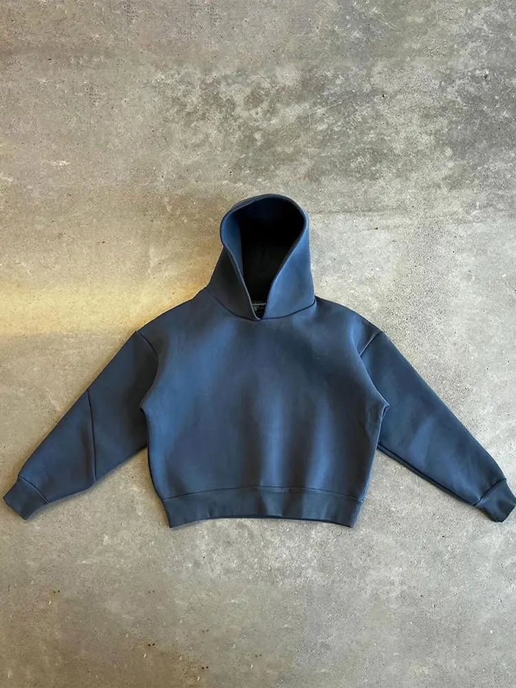 Felpa con cappuccio blu scuro su sfondo grigio, design minimalista, moda casual, abbigliamento streetwear, tendenza autunno inverno.