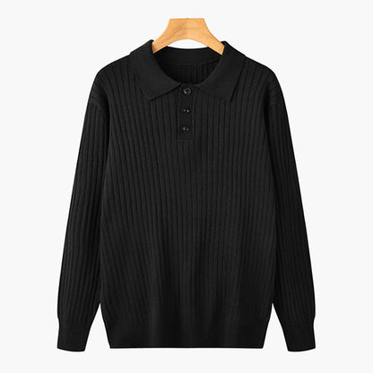 Maglione nero a coste con colletto e bottoni, appeso su gruccia di legno. Moda uomo, abbigliamento invernale elegante e casual.