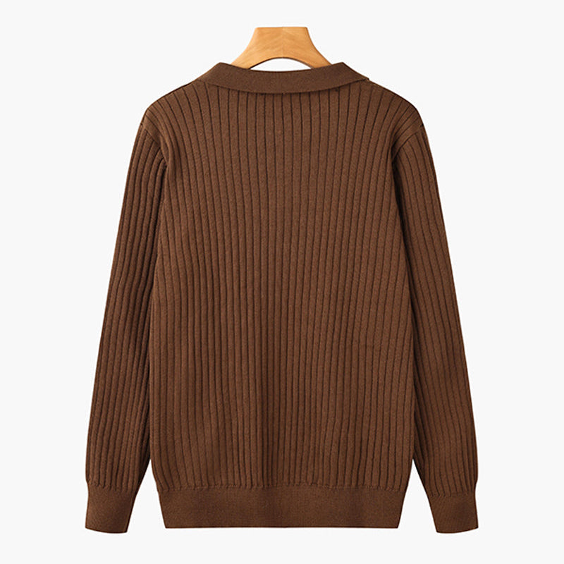 Maglione marrone a coste, maniche lunghe, su gruccia di legno. Moda autunnale, abbigliamento casual, tessuto caldo e confortevole.