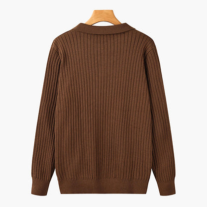 Maglione marrone a coste, maniche lunghe, su gruccia di legno. Moda autunnale, abbigliamento casual, tessuto caldo e confortevole.