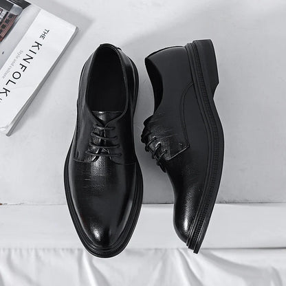 Scarpe eleganti nere in pelle lucida su sfondo bianco, con libro "The Kinfolk" accanto. Scarpe da uomo formali, moda classica, stile raffinato.