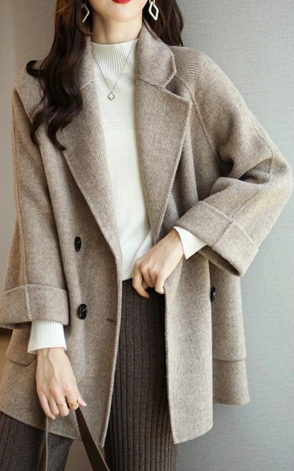 Donna con cappotto beige elegante, maglione bianco e pantaloni a coste marroni. Moda autunnale, stile casual chic, abbigliamento femminile moderno.