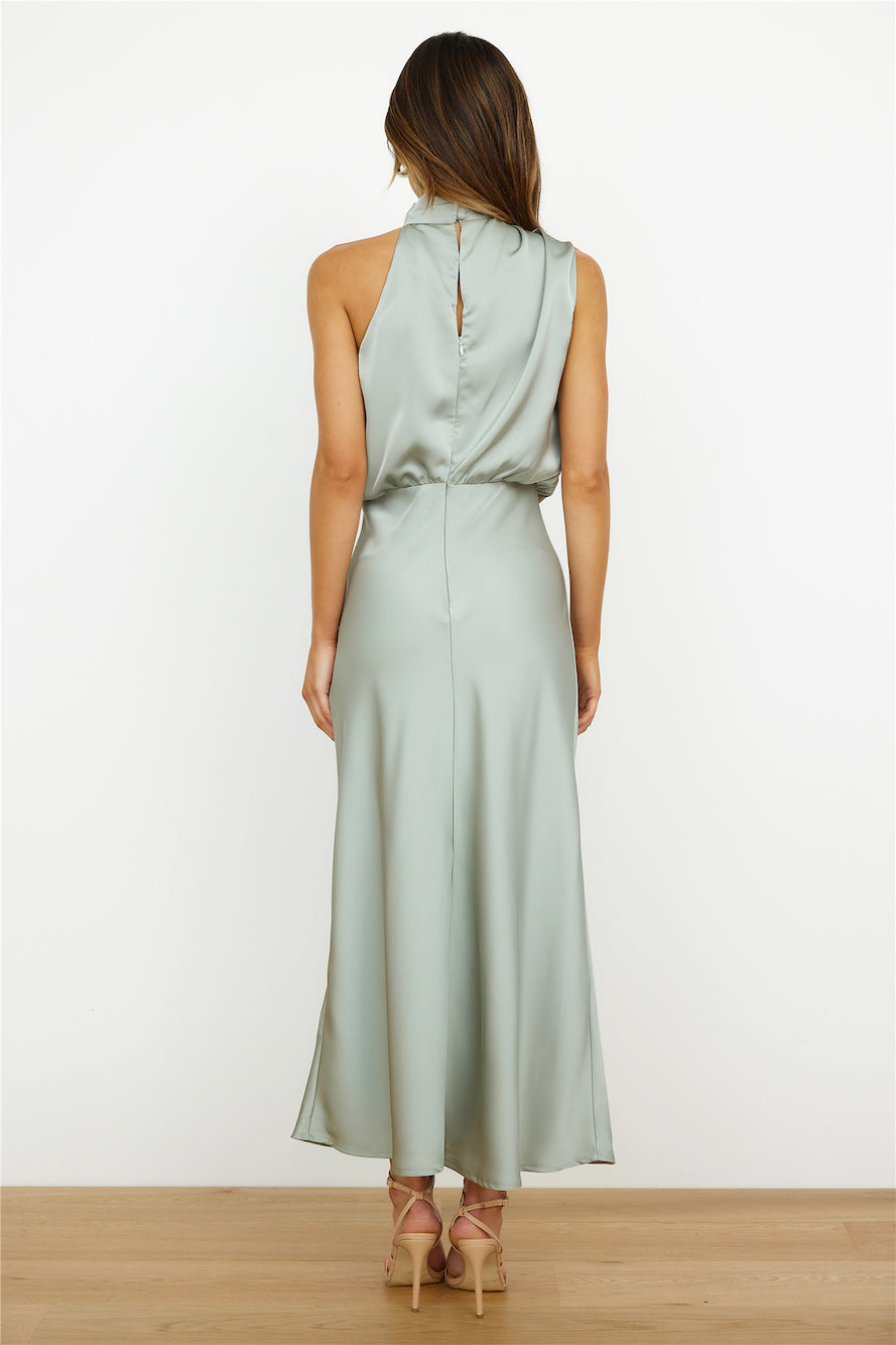 Abito lungo in raso verde salvia, senza maniche, con scollo alto e schiena scoperta. Elegante e moderno, perfetto per eventi formali.