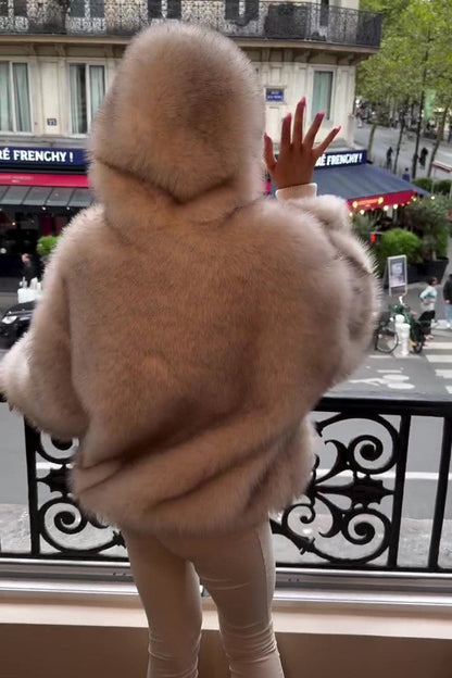 Donna in cappotto di pelliccia beige su balcone parigino, vista su strada trafficata. Moda invernale, eleganza urbana, Parigi.