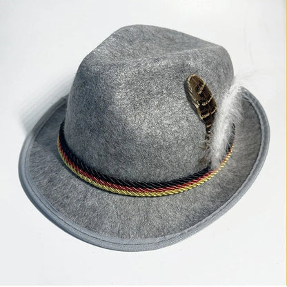 Cappello tirolese grigio in feltro con cordoncino tricolore e piuma decorativa. Accessorio tradizionale alpino, moda bavarese, Oktoberfest.