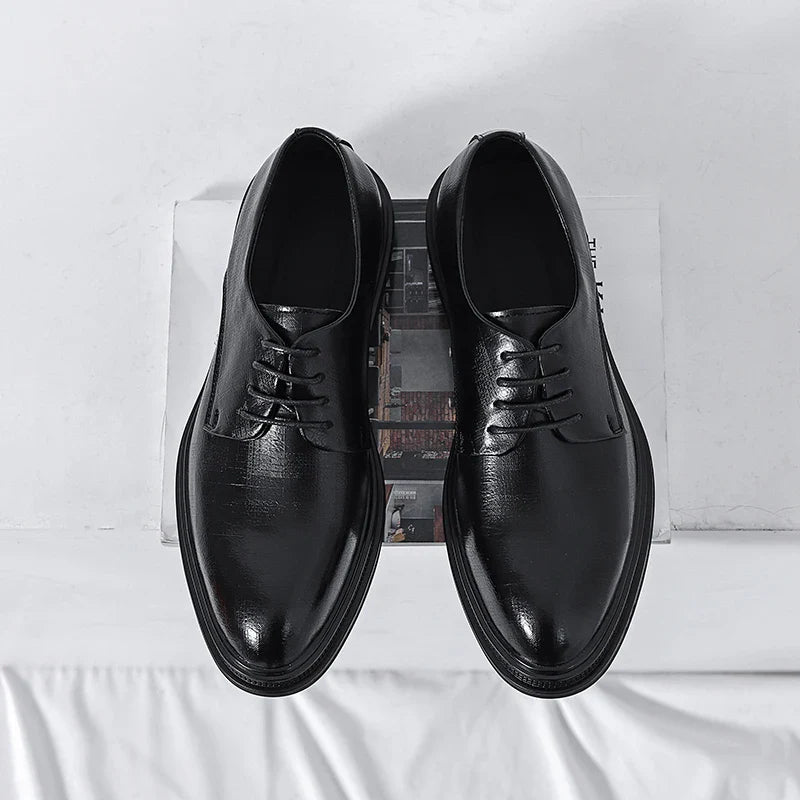 Scarpe eleganti nere in pelle lucida, vista dall'alto su sfondo bianco. Calzature formali da uomo, stile classico, ideali per ufficio o cerimonie.