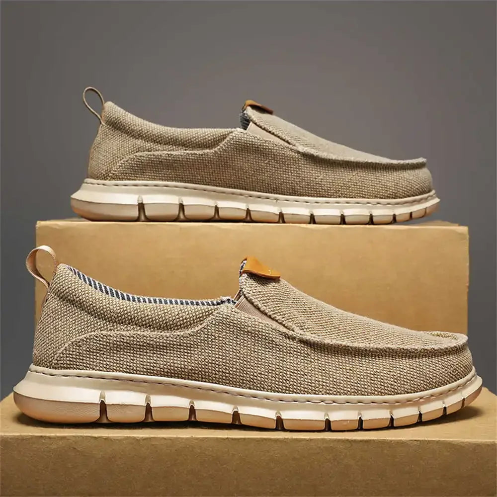Scarpe slip-on beige in tessuto traspirante su scatole di cartone. Design casual, suola flessibile, ideali per comfort e stile quotidiano.