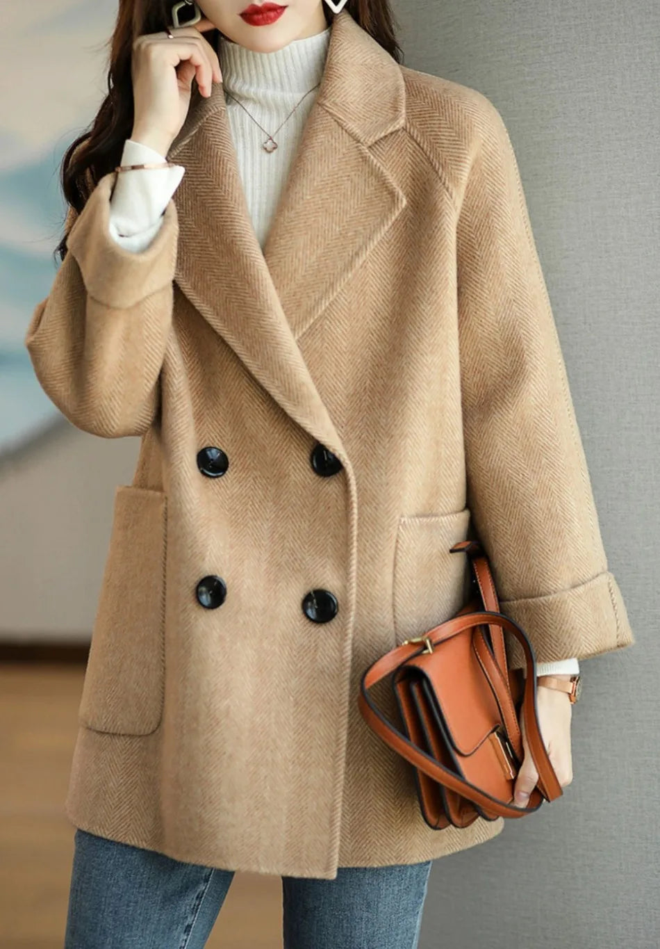 Donna con cappotto beige elegante, doppio petto, tasche grandi, abbinato a borsa marrone e jeans. Moda autunnale, stile casual chic.