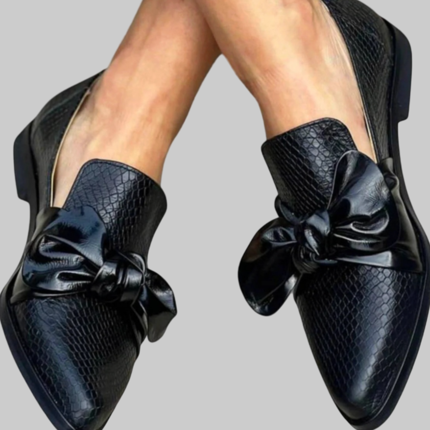 Scarpe eleganti nere in pelle con motivo a serpente e fiocco decorativo, moda donna, calzature di lusso, stile sofisticato, tendenza autunno inverno.