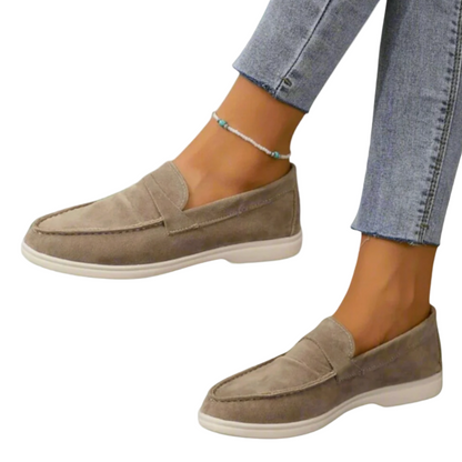 Scarpe mocassini donna in camoscio beige, suola bianca, abbinate a jeans aderenti. Calzature eleganti e casual, ideali per moda femminile.