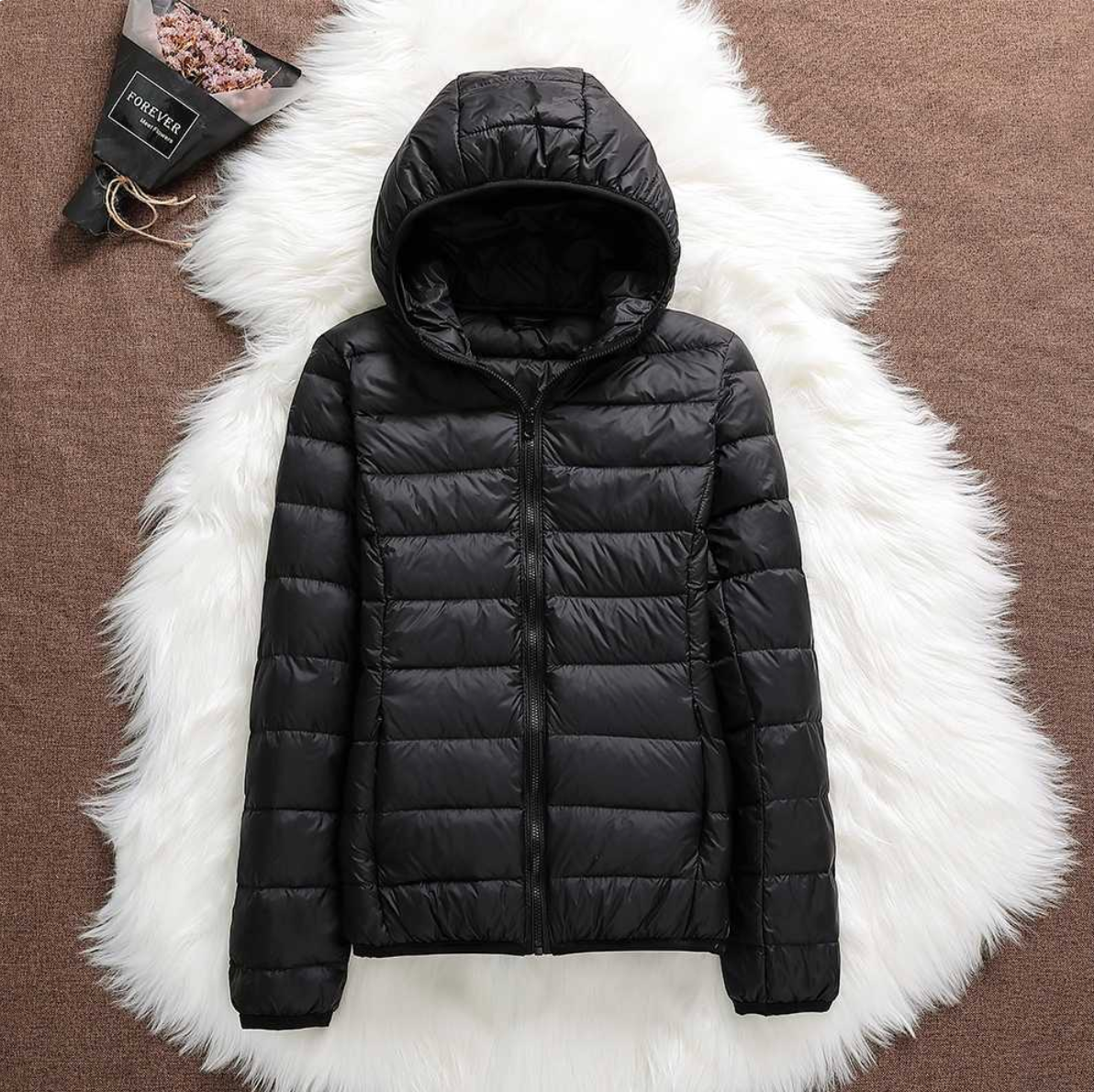 Giacca invernale nera con cappuccio su sfondo bianco peloso, design trapuntato, chiusura a zip, moda uomo, abbigliamento caldo e casual.