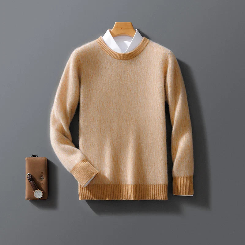 Maglione beige in cashmere su gruccia, con camicia bianca sotto, accanto a portafoglio marrone e orologio. Elegante abbigliamento invernale uomo.