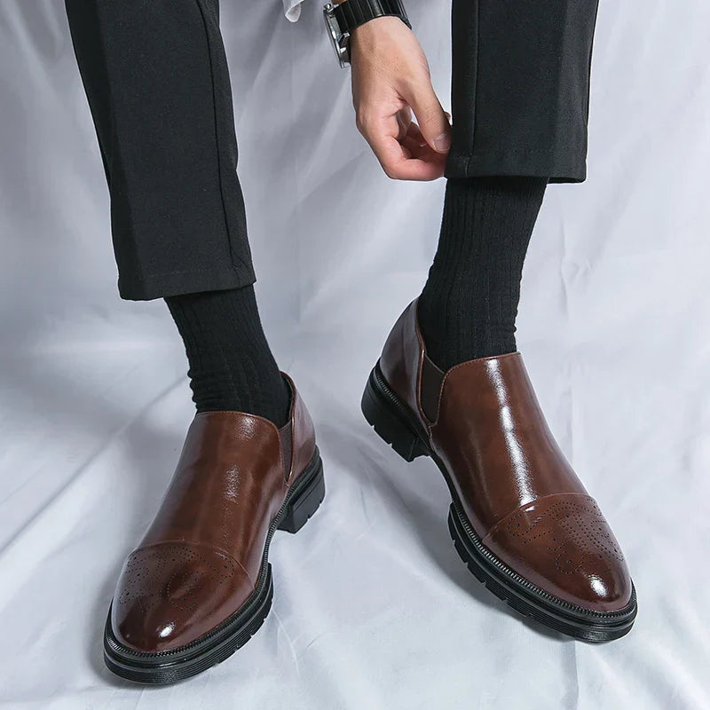 Scarpe eleganti uomo in pelle marrone, indossate con pantaloni neri e calzini scuri. Design classico, ideale per abbigliamento formale e business.