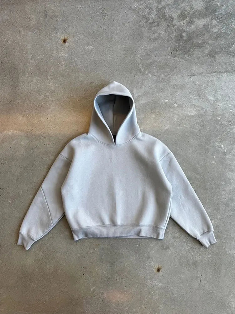 Felpa con cappuccio grigia su sfondo di cemento, moda casual, abbigliamento streetwear, design minimalista, tendenza autunno inverno.