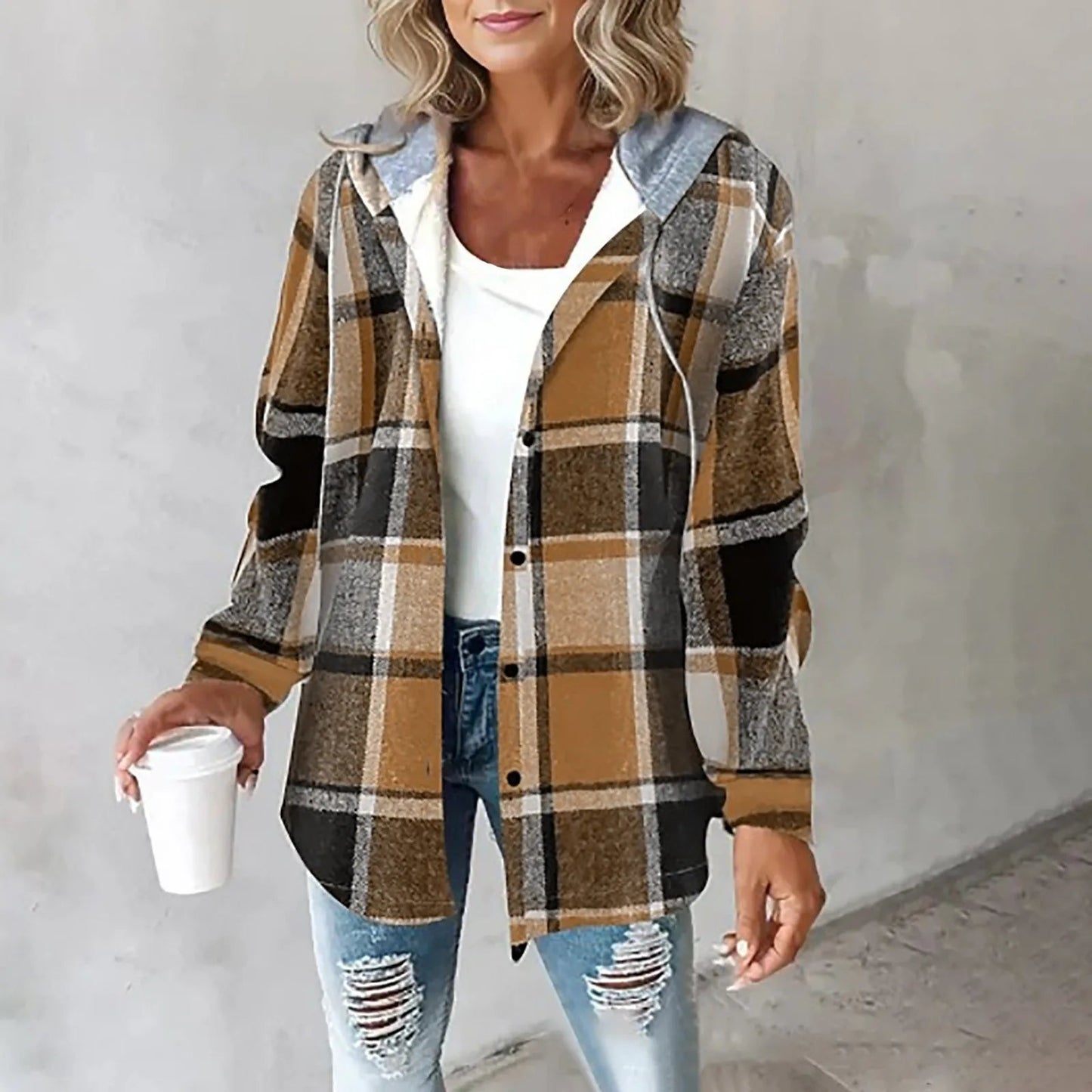 Donna con camicia a quadri marrone e bianca, jeans strappati, e tazza di caffè. Moda casual autunnale, abbigliamento femminile trendy.