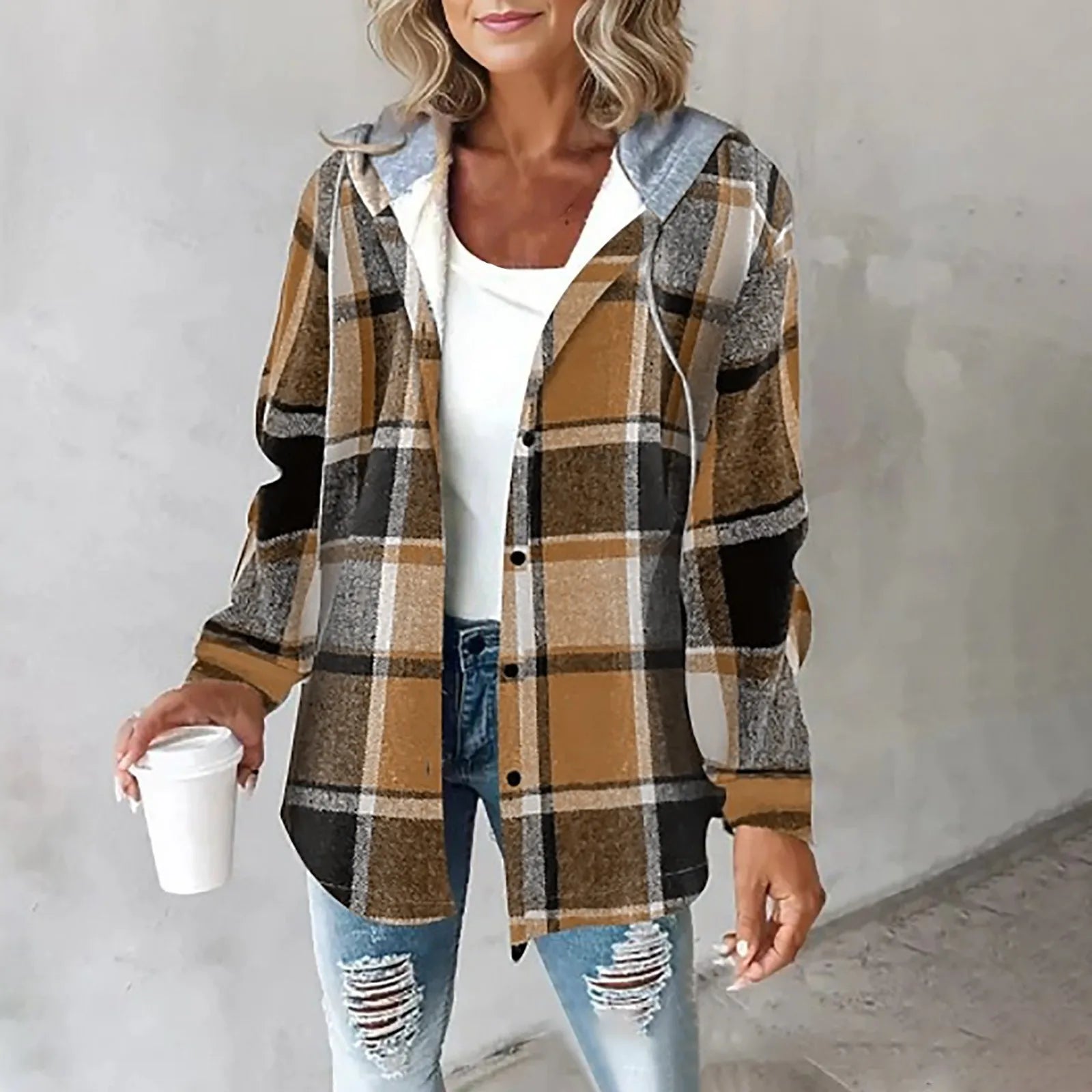 Donna con camicia a quadri marrone e bianca, jeans strappati, e tazza di caffè. Moda casual autunnale, abbigliamento femminile trendy.