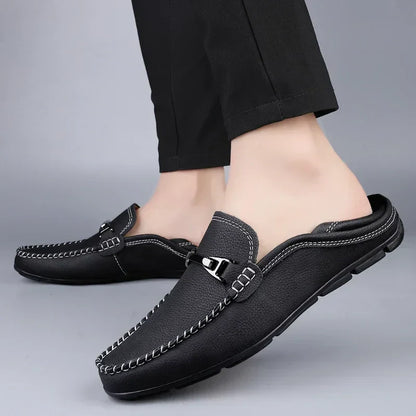 Scarpe mocassini da uomo in pelle nera, design elegante con cuciture bianche, indossate con pantaloni neri. Calzature casual e comode.