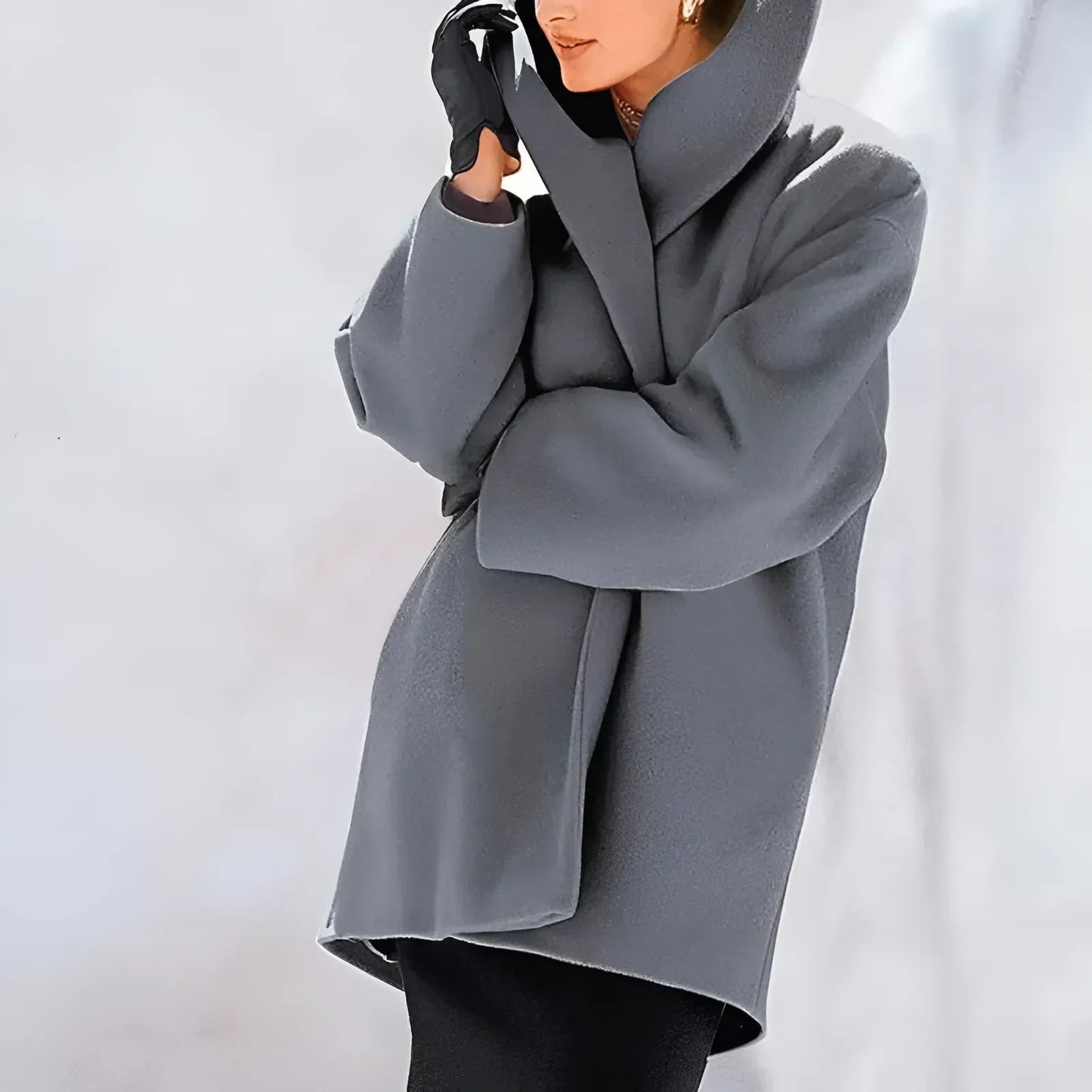 Cappotto grigio elegante in lana, design moderno, indossato con guanti neri. Moda invernale donna, stile sofisticato e minimalista.