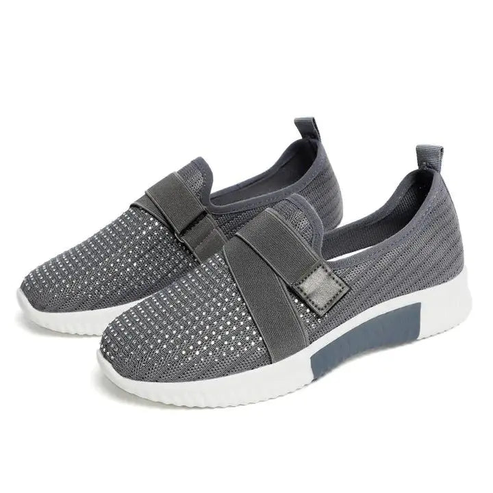 Scarpe slip-on grigie da donna, tessuto traspirante, suola bianca in gomma, design casual e moderno, ideali per camminate e tempo libero.