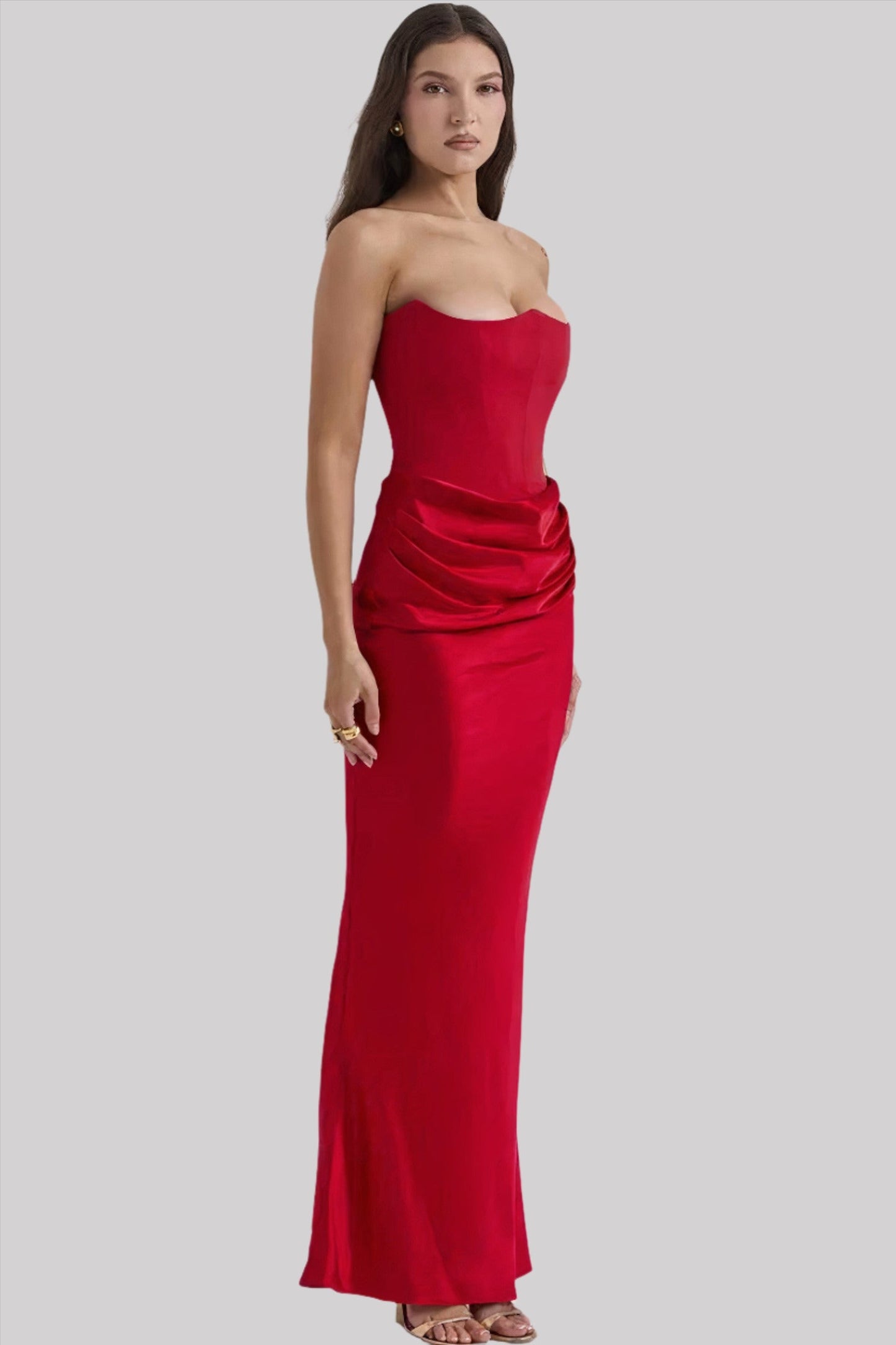 Donna in abito lungo rosso elegante, senza spalline, con drappeggi laterali. Moda femminile, abbigliamento da sera, stile sofisticato.