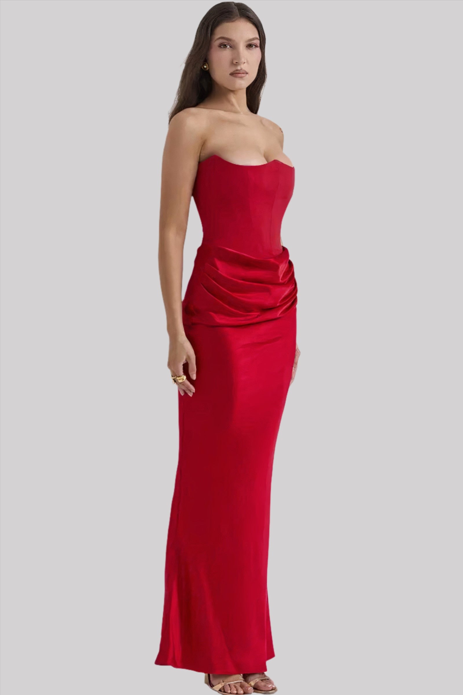 Donna in abito lungo rosso elegante, senza spalline, con drappeggi laterali. Moda femminile, abbigliamento da sera, stile sofisticato.