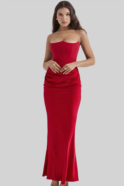 Donna in abito lungo rosso elegante, senza spalline, con drappeggio in vita. Moda femminile, abbigliamento da sera, stile sofisticato.