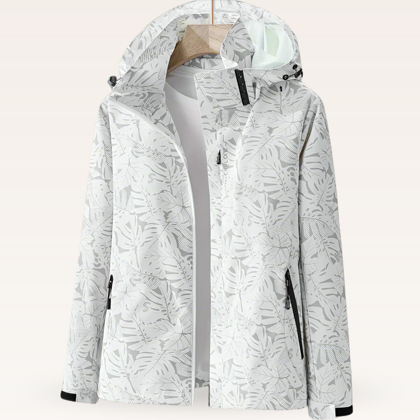 Giacca impermeabile bianca con cappuccio, motivo foglie grigie, chiusura zip, tasche laterali, ideale per outdoor e trekking.