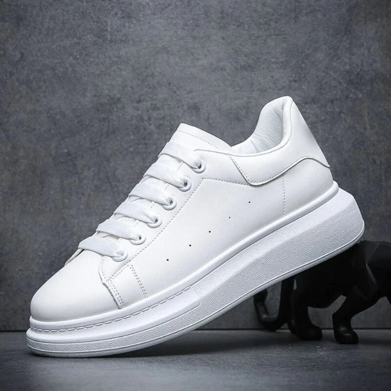 Scarpa da ginnastica bianca su sfondo grigio, design minimalista, suola spessa. Scarpe sportive moda, tendenza calzature casual uomo e donna.