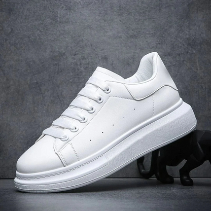 Scarpa da ginnastica bianca su sfondo grigio, design minimalista, suola spessa. Scarpe sportive moda, tendenza calzature casual uomo e donna.