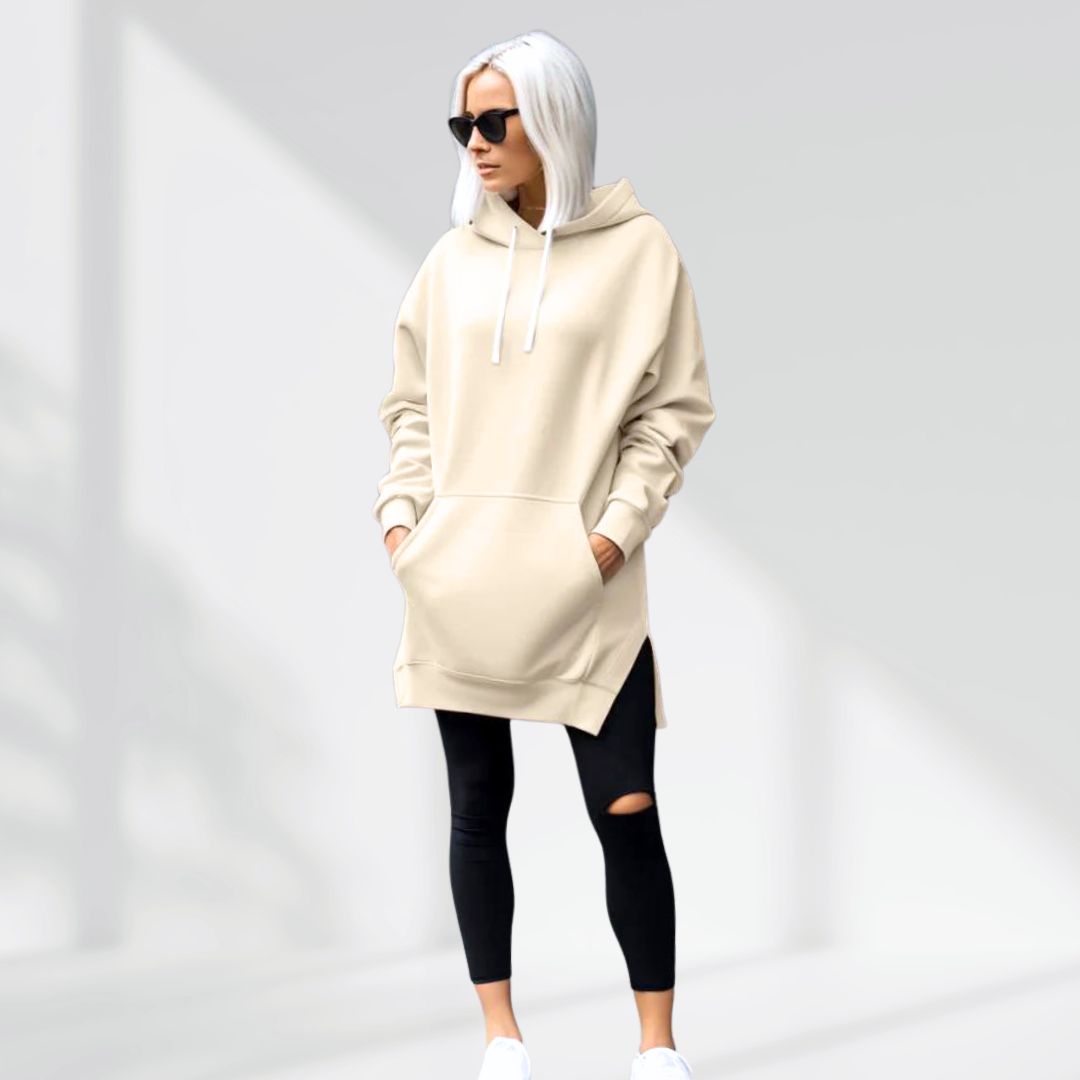Donna con felpa beige oversize, leggings neri strappati e occhiali da sole. Moda casual urbana, stile streetwear, tendenze abbigliamento 2023.