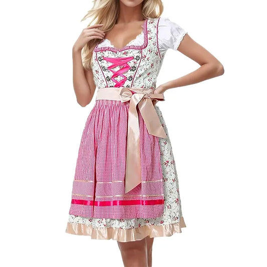Donna in abito tradizionale dirndl bavarese rosa e bianco, con corpetto a lacci e grembiule a quadretti. Abbigliamento Oktoberfest elegante.