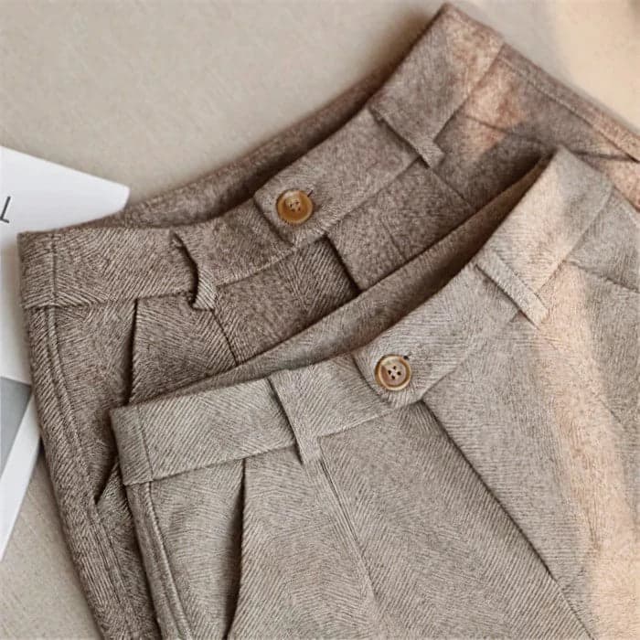 Due pantaloni di lana beige e marrone chiaro, pieghe eleganti, bottoni in legno, tessuto a spina di pesce, moda autunnale, abbigliamento casual chic.