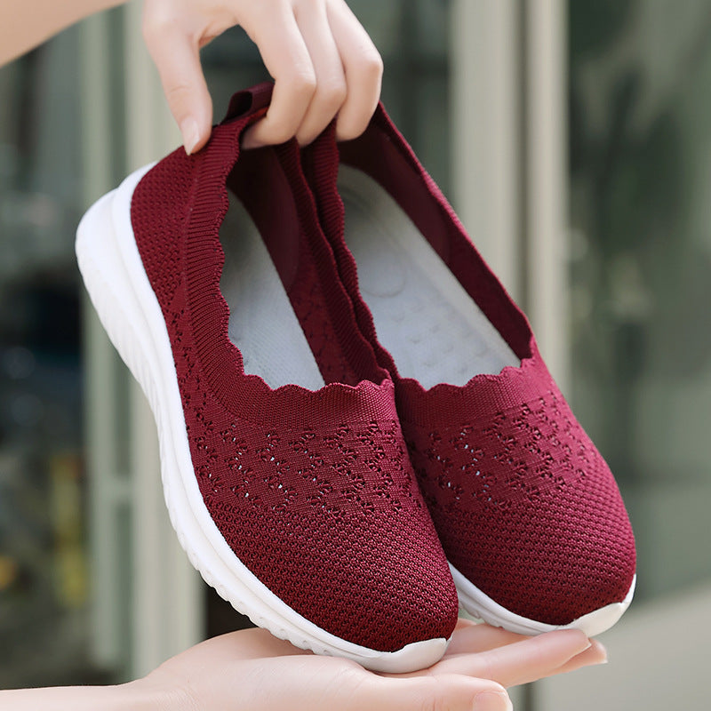 Scarpe da donna rosse in maglia traspirante, suola bianca antiscivolo, design senza lacci, ideali per camminata e comfort quotidiano.