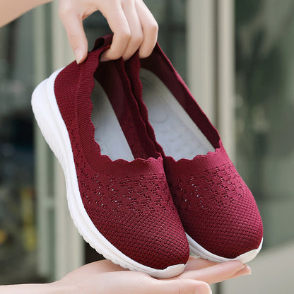 Scarpe da donna rosse in maglia traspirante, suola bianca antiscivolo, design senza lacci, ideali per camminata e comfort quotidiano.