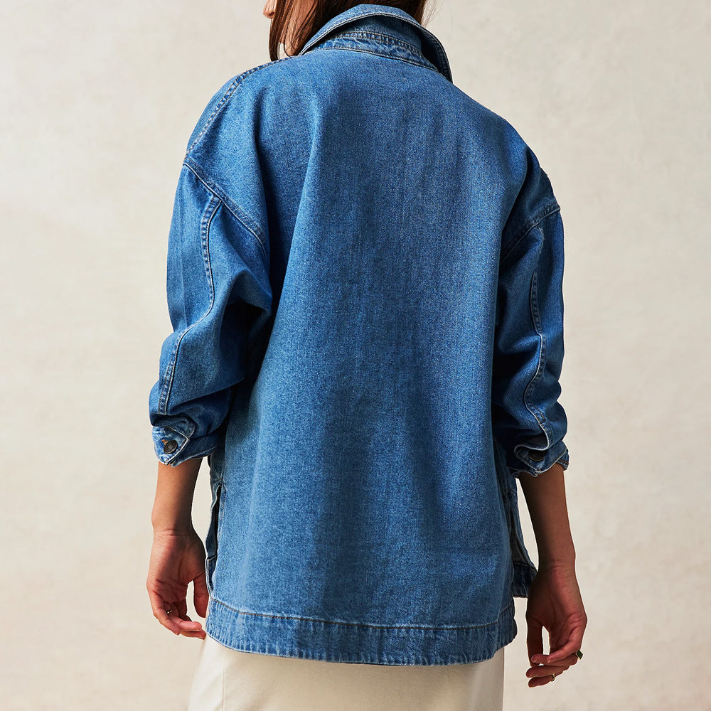 Giacca di jeans oversize blu su sfondo neutro, indossata da una persona di spalle. Moda casual, tendenza denim, abbigliamento unisex.