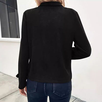Donna con giacca nera elegante vista da dietro, jeans blu scuro, sfondo bianco minimalista. Moda casual autunnale, stile urbano chic.