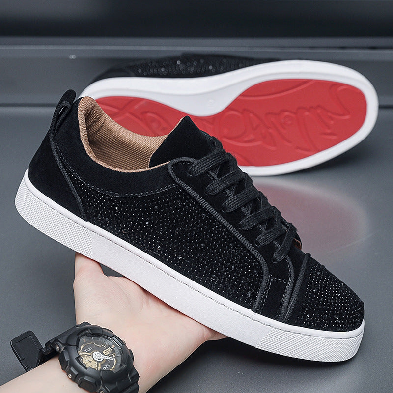Scarpe da ginnastica nere con strass, suola bianca e dettagli rossi, tenute in mano. Scarpe eleganti e moderne, perfette per moda casual.