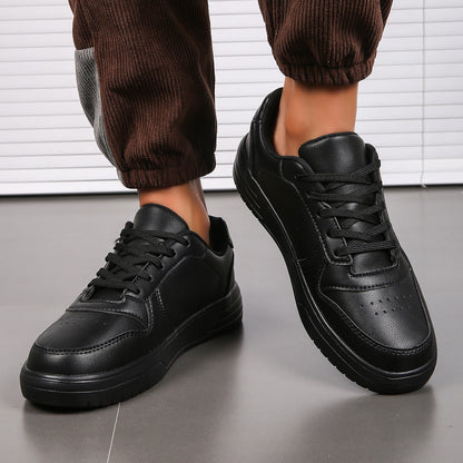 Scarpe da ginnastica nere in pelle, design moderno, suola robusta, indossate con pantaloni marroni. Scarpe sportive eleganti per uomo.
