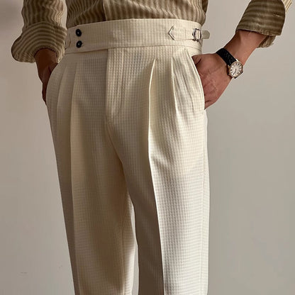 Pantaloni eleganti bianchi a vita alta con cintura regolabile, indossati con camicia a righe beige. Stile classico maschile, moda uomo.