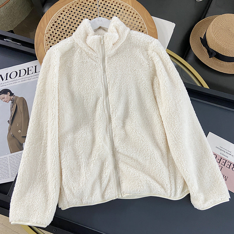 Giacca in pile bianco crema su tavolo, moda autunno inverno, chiusura zip, stile casual, tessuto morbido e caldo, ideale per look eleganti e confortevoli.